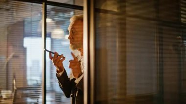 Akşamları cep telefonuyla ofis koridorunda yürüyen yetenekli bir yönetici. Yaşlı işadamı koridordaki akıllı telefondan sesli mesaj kaydediyor. Ses tanıma uygulaması kullanan kıdemli CEO.