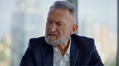 Gergin iş adamı çalışma yerinde resmi takım elbise içinde oturma sorunu yaşıyor. Memnuniyetsiz yaşlı girişimcinin portresi, ofisteki mali sorunlar üzerine kafa yoruyor. Sakallı yönetici görünümlü kararlar.