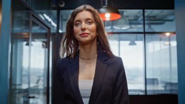 Zengin iş kadını koridorda yürüyor modern iş merkezleri kapanıyor. Gülümseyen kadın CEO salondaki meslektaşlarıyla el sallıyor. Kendine güvenen bayan patron zarif bir takım elbiseyle şirket koridoruna çıkıyor..