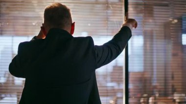 Siluet işadamı camdan ofis duvarına yaslanmış cep telefonunu arıyor. Zarif takım elbiseli profesyonel yönetici koridorda cep telefonuyla konuşuyor. Akıllı telefondan yönetici çalışmaları tartışıyor.