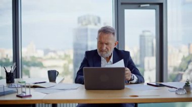 Şirket ofisinde tatmin olmamış ifadeler içeren belgeleri analiz eden profesyonel muhasebeci. Gergin kıdemli işadamı iş kağıtlarını çöpe atıyor. Kızgın yönetici duygusal olarak bilgisayarı kapatıyor