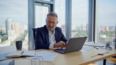 Bilgisayarda çalışan analist, şirket işyerindeki yakın çekimde evraklara bakıyor. Yaşlı işadamı, ofiste yatırım projesi oluşturan notlar yazıyor. Gergin yönetici karar vermekte zorlanıyor