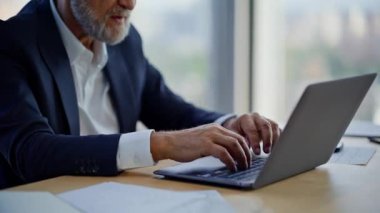 Şirket işyerindeki projede klavye yazan kıdemli yönetici. Modern ofiste zor sorunları çözen ciddi bir iş adamı. Çalışma alanında çatık kaşlı yönetici tarama bilgisayarı.