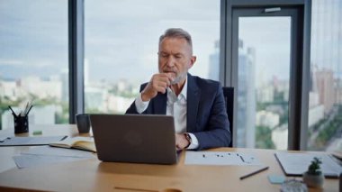 Modern çalışma alanının kapanış stratejisi üzerine düşünen yaşlı yatırımcılar. Gri saçlı işadamı ofis panoramik penceresinde pazarlama projesi üzerinde kafa yoruyor. İş yerinde çalışan zarif yönetici dizüstü bilgisayar.