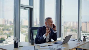 Şirket işyerinde kıdemli bir çalışan akıllı telefona gülüyor. Mutlu gri saçlı işadamı cep telefonu konuşmalarıyla iş başarısını paylaşıyor. Neşeli yönetici ofisteki dostça telefon iletişiminin keyfini çıkarıyor.