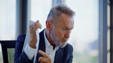 Videoyu arayan patron, ofisteki mali sorunlardan yakınıyor. Üst düzey işadamı, sanal toplantının stresiyle kağıtları fırlatıyor. Gergin yönetici online konferansta tartışıyor