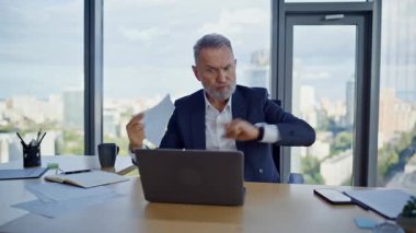 İş adamı video yüzünden kavga ediyor. Ofiste duygusal olarak kağıtlar dağılıyor. Öfkeli yaşlı yönetici stresli sanal toplantı dökümanını bitirdi. Kızgın patron online konferansta tartışıyor..