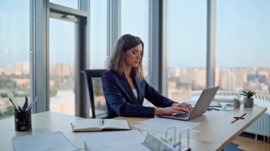 Ofiste çalışan meşgul bir girişimci dizüstü bilgisayarı yakından inceliyor. Modern işyerlerinde bilgisayar yazıları yazan ciddi bir iş kadını. Zarif kadın yönetici kapalı alanda yatırım projesi geliştiriyor..