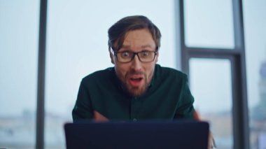 Şirket ofisindeki web kamerasına kağıtları fırlatmak için agresif yönetici videosu. Öfkeli iş adamı internette toplantılara bağırıyor. Gözlüklü çılgın patron bilgisayarı kapatıyor..