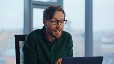 Ofis çalışanı internetten arıyor. Şirket işyerindeki internet kamerasına işaret veriyor. Arkadaş canlısı iş adamı sanal toplantıda iş planını açıklıyor. Gülümseyen patron iş hakkında konuşurken gözlüklerini çıkarıyor..