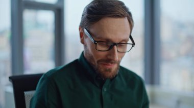 Şirket çalışanı hafif bir iç mekanda çalışıyor. Portre sakallı müdür ofis panoramik penceresinde oturan akıllı telefona cevap veriyor. Gülümseyen işadamı iş yerinde cep telefonundan konuşuyor..