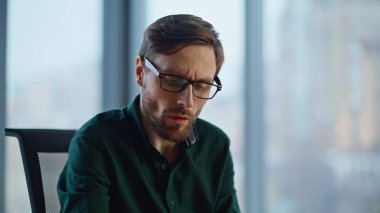 Düşünceli bir yönetici hafif ofis iç çekimlerinde pazarlama stratejisi geliştiriyor. Düşünceli iş adamı gözlük takıyor ve iş projesini düşünüyor. Başlangıçta sakallı girişimci düşüncesi çözüm arayışı