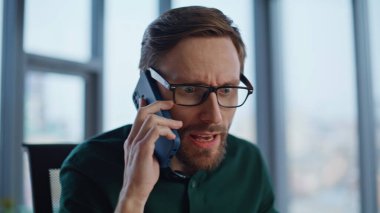 Ofiste akıllı telefondan bağıran çılgın iş adamı. Cep telefonuyla bağıran kızgın yönetici stresli sohbeti duygusal olarak bitiriyor. Gergin CEO 'nun gözlüğünü çıkarması hayal kırıklığı yaratıyor..