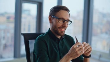 Yaratıcı iş adamı ofis panoramik penceresinde fikirler üzerinde kafa yoruyor. Kahvesini yudumlayan gülümseyen yönetici elinde kalem tutarak iş başarısını düşünüyor. İş yerinde girişim yaratan yakışıklı girişimci.