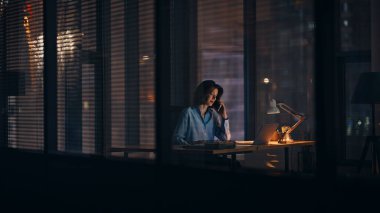 Girişimci gecenin geç saatlerinde karanlık çalışma alanında cep telefonunu tartışıyor. Gergin iş kadını stresli akıllı telefon konuşmasını fazla mesai yaparak bitirir. Öfkeli kadın yöneticinin işi bitti..