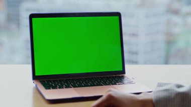 Kız parmak şıklatma yeşil ekran dizüstü bilgisayar klavyesi şehir manzarası ev kapanışında video dersine başlıyor. Meçhul kadın, modern bilgisayarı model ekranıyla açıyor. Uzaktan inceleme için teknoloji kullanan bir bayan. 