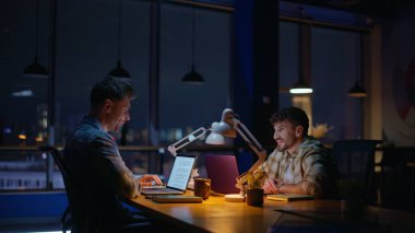 Mesai arkadaşları çalışma alanında gayri resmi iletişim kuruyor. Akşam işyerinde gülen iki takım üyesi. Mutlu ortaklar iş yerinde arkadaşça sohbetin tadını çıkarıyor. 