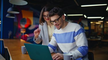 İş adamları sanal toplantı hakkında konuşuyor renkli ofislerde dizüstü bilgisayar arıyorlar. Yaratıcı ajans binasından kendine güvenen iş arkadaşları video çağrısı. Ortaklar çevrimiçi konferansta işi tartışıyor. Takım çalışması. 