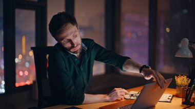 Çok çalışan girişimci, dizüstü bilgisayarını kapatıp lamba ışığında karanlık işyerinde oturuyor. Yorgun iş adamı işi bitirdiğinde bitkin hisseder. Yorgun adam, gece geç saatlere kadar çalışmaktan aciz..