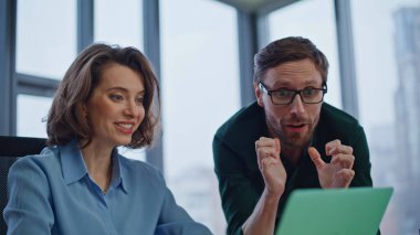 Duygusal iş arkadaşları zafer kutlamalarıyla ofisteki bilgisayara yakın çekim yapıyorlar. Coşkulu meslektaşlarımız harika haberler okuyarak başarılarını paylaşıyorlar. Heyecanlı yöneticiler iş yerinde iş başarısının keyfini çıkarıyorlar.