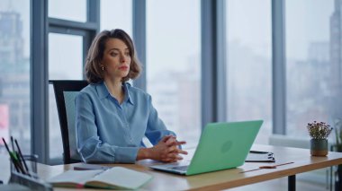 Modern ofiste çalışan bir kadın yönetici dizüstü bilgisayar yaratıyor. İş yerinde bilgisayar geliştiren güzel bir iş kadını. Ciddi bir girişimci masasında oturup iş çözümleri üzerinde kafa yoruyor..