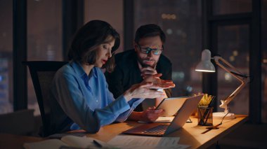 İş kadını, proje sorunlarını gece ofisinde deneyimli bir yöneticiye anlatıyor. Bilgisayara bakıp hatayı tartışan iki meslektaş. Endişeli takım yöneticileri iş sorunlarını birlikte çözüyor..