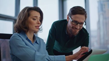 Kendine güvenen meslektaşlar, modern iş yerinde raporları yakın planda tartışırlar. Gülümseyen iş adamları şirket ofisindeki iş belgelerini inceliyor. İstatistiksel verilerle çalışan iki iş arkadaşı.