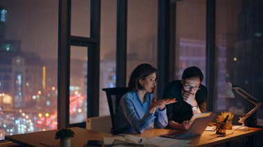 Gergin iş arkadaşları, gece ofisindeki internet projesini analiz ediyorlar. İki iş ortağı gecenin geç saatlerinde yazılım hatasını tartışıyor. Endişeli iş kadını, gözlüklü adama sorunları açıklar.