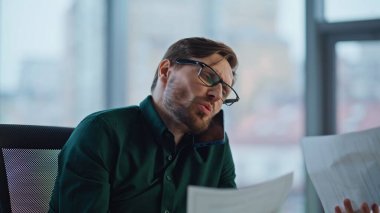 Şirket işyerindeki belgeleri görüşmek için iş adamını arıyorum. Gülümseyen işletme yöneticisi akıllı telefondan iş gazetelerini okuyor. Ofiste cep telefonuyla başarılı bir başlangıç müzakeresi