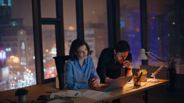 Stresli iş arkadaşları gece vardiyasında anlaşamıyor. Mutsuz meslektaşlar, online proje başarısızlığından endişe ediyorlar. Ofiste fazla mesai yapıyorlar. Memnun olmayan takım dizüstü bilgisayarı kapattı ve akşam geç saatlerde kötü haber verdi.