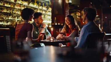 Lüks restoranda iki çift buluşuyor. Grup mutlu arkadaşları modern bar içinde keyifli bir iletişimin tadını çıkarıyorlar. Rahat erkekler hafta sonları gülüp eğlenen kadınlar. Arkadaşlık kavramı.