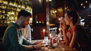 Rahatlamış insanlar barda sigara içiyor ve hafta sonları toplanıp eğleniyorlar. Karanlık bardaki kaygısız buluşmada gülen mutlu arkadaşlar. Gülümseyen milenyumlar barda takılıyor. Nikotin bağımlılığı kavramı.