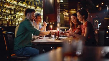 Erkekler sıcak restoranda gece buluşmalarında kadınlara menü veriyor. Grup gençleri hafta sonu lüks bir kafede buluşuyorlar. Gülümseyen arkadaşlar bar masasında içki seçmeyi konuşuyor. İlişki kavramı.