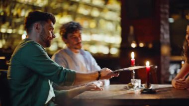 Çağdaş restoranlarda çiftler randevularında menü okuyan gençler. Gülümseyen erkek kadın içkiyi tercih ediyor. Barda buluşuyorlar. Mutlu arkadaşlar, Karanlık Bar 'da dostça buluşuyorlar..