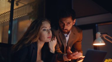 Portre, iş arkadaşlarının gece iş yerinde fazla mesai yaparak sorun çözdüğünü vurguladı. Karanlık odada gergin hisseden iki endişeli iş arkadaşı. Duygusal erkek kadın kararını akşam geç saatlerde tartışıyor.