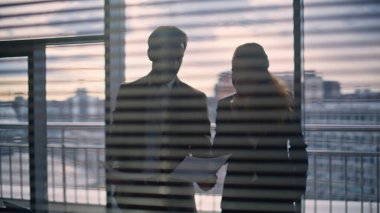 İş adamlarının siluetleri kasvetli şehir merkezini kapatan belgeleri çeviriyor. Seçkin yönetmen yardımcısı kadın kitap sözleşmesi. İş adamı müdürü iş görüşmesi yapıyor.