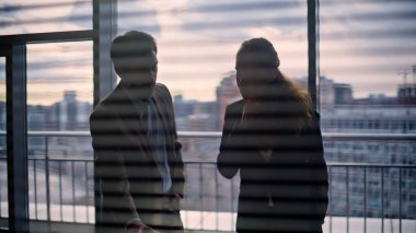 Şirket çalışanları şehir mimarisi manzaralı işyerindeki projeyi tartışıyor. İş adamları, Panorama ofisinde el sıkışma anlaşmasını sonuçlandırıyor. Gülümseyen pozitif ortaklar başarılı anlaşmanın tadını çıkarıyor