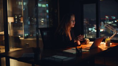Sinirli yönetici, gece ofisinde bilgilendirme e-postasını okuyor. Bilgisayarda çalışan kadının kötü haber alması şok etkisi yarattı. Stresli iş kadını masadaki bilgisayar problemi çözümünü kapatıyor 