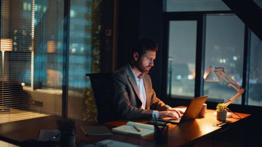 Sessiz ofis ortamında gece geç saatlerde boyun kaslarını esneten yorgun bir yönetici. Bitkin düşmüş işçiler projeyi tamamladıktan sonra cihazı kapatıyor. Yönetici kabinede kitapçığı çeviriyor