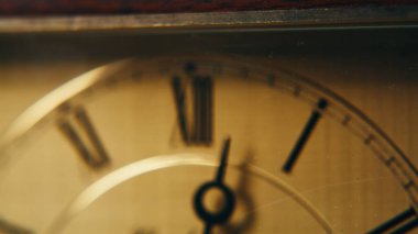 Retro el, akşam ışıklarıyla zamanı gösteriyor. Makro manzaralı klasik saat ölçüm süresi. Kapalı alanda Roma rakamlarıyla daire tuşla. Klasik zaman diliminde kara ok. Eski zaman bekçisinin çalışma saatleri.