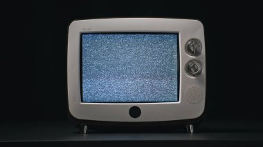 Siyah arkaplanda titreşen eski bir televizyon masası. Retro monitörde titreşen beyaz ses. Eski bir televizyon kanalı sinyali bozuyor. CRT parlayan statik görüntüsü.