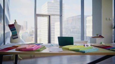 Katlanmış kumaş örnekleri çalışma alanı yaratıcı stüdyo kapanışında duruyor. Masa moda ajansına renkli tekstil tasarımı çizimleri yerleştirildi. Modern ofiste terzilik için parlak malzemeler.