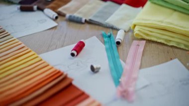 Renkli palet kumaş örnekleri ve dikiş aletleri masa terziliği stüdyosuna yakın duruyor. Tasarım ajansının atölyesine kumaş örnekleri yerleştirildi. Moda atölyesi projesi için parlak tekstil. Tekstil endüstrisi