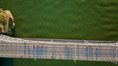 Aerial view pedestrians walking bridge Dom Luis crossing Douro river. Top shot people crossing monumental metal construction connecting coasts beautiful Porto. Portugal city architecture sunny day.