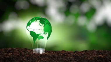 Yeşil dünya haritası yenilenebilir enerji ve sürdürülebilir enerji kaynaklarını temsil eden bir ampulde.