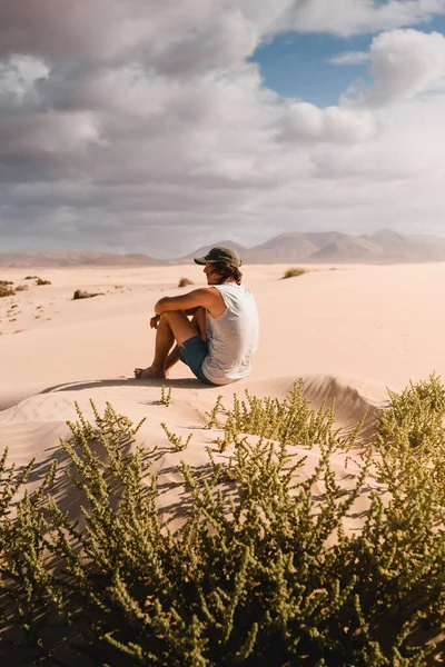 Молодий Чоловік Кепкою Сидить Пустельному Піску Дюн Корралехо Фуертевентурі Споглядаючи — стокове фото