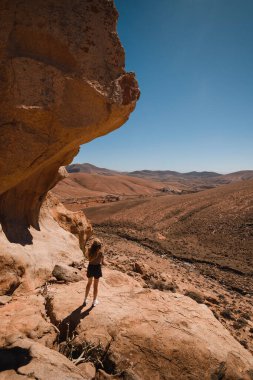 Kanarya Adaları 'ndaki Fuerteventura dağlarının çöl manzarasında bir kız.