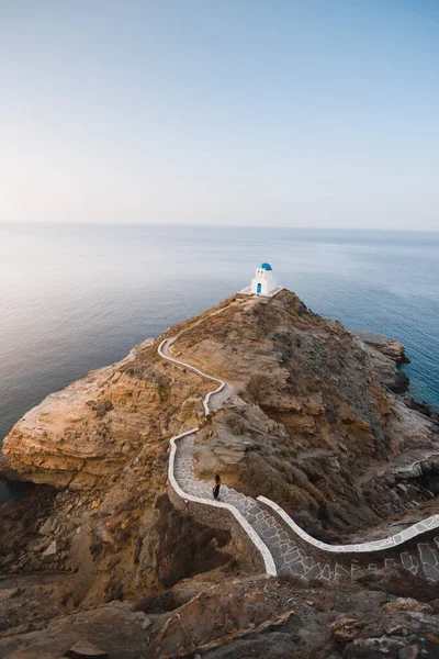 stock image Person on the way to the beautiful Kastro church on top of a cliff, surrounded by the sea on the Greek island of Sifnos