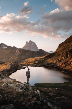 Günbatımında Midi d 'Ossau tepesi ve Anayet İbonları ile manzara Pyrenean dağlarının manzarasının keyfini çıkaran bir adamla.