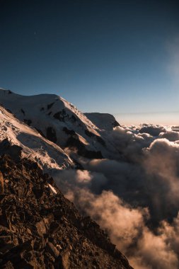 Valle Blanche 'ın sırtlarından geçen dağcılar, Mont Blanc' ın kitle tepeleri tarafından çerçevelenmiştir.